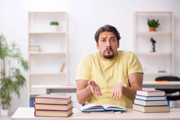 Jonge mannelijke student bereidt zich voor op examens in de klas — Stockfoto