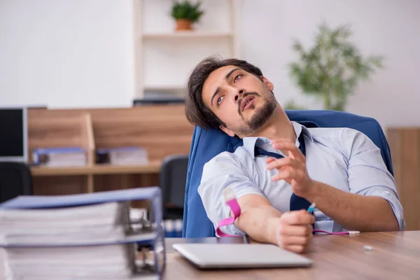 Joven hombre drogadicto empleado en el lugar de trabajo — Foto de Stock