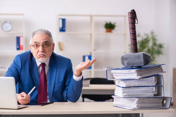 Старий чоловік працівник незадоволений занадто великою роботою в офісі — стокове фото