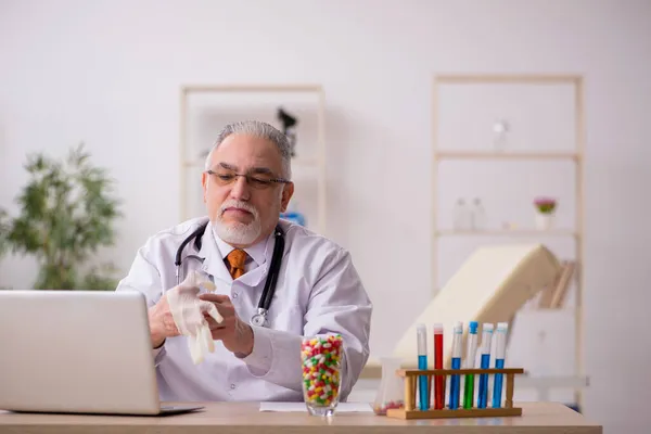 Gammal manlig läkare farmaceut som arbetar på kliniken — Stockfoto