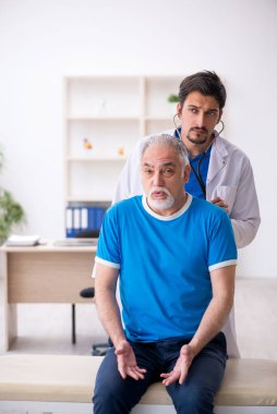 Yaşlı erkek hasta genç erkek doktoru ziyaret ediyor.