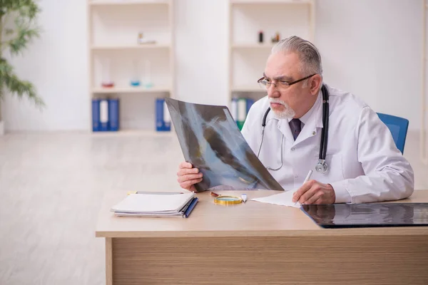 Old male doctor radiologist working in the clinic during pandemi — Stock Photo, Image