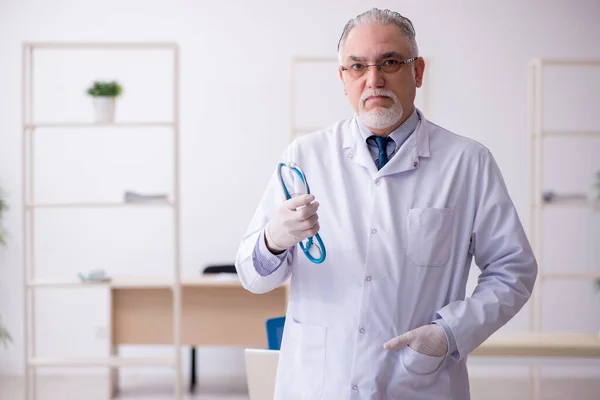 Viejo médico que trabaja en la clínica — Foto de Stock