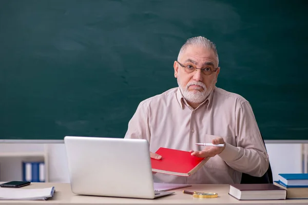 Oude mannelijke leraar voor schoolbord — Stockfoto