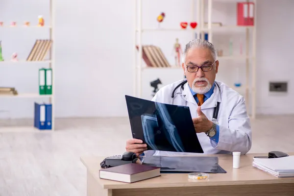 Klinikte çalışan yaşlı bir erkek radyolog. — Stok fotoğraf