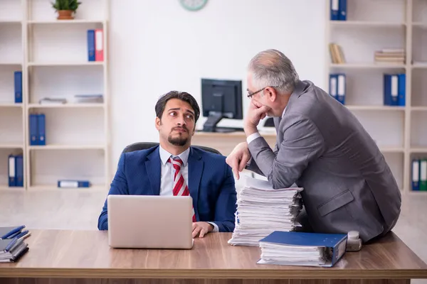 Zwei männliche Mitarbeiter arbeiten im Büro in Mobbing-Konzept — Stockfoto