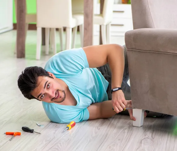 Muž opravuje nábytek doma — Stock fotografie
