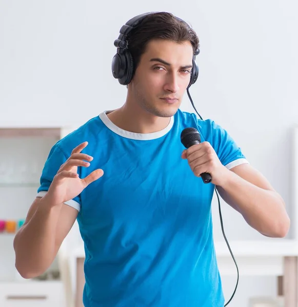 Jovem homem bonito cantando karaoke em casa — Fotografia de Stock