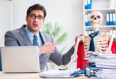 İskeletle çalışan bir iş adamı.