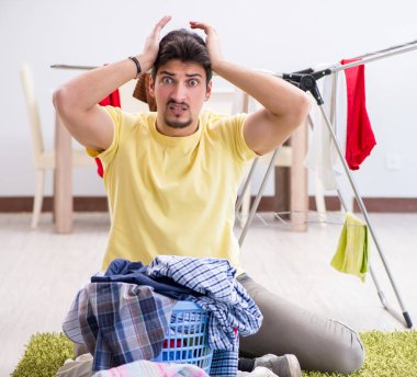 Yakışıklı koca evde çamaşır yıkıyor.