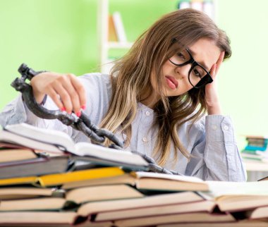 Genç kız öğrenci masaya zincirlendi ve sınavlara hazırlanıyor.