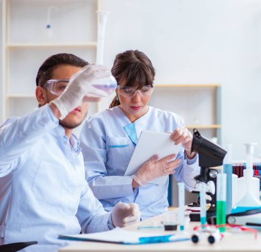 Laboratuvarda çalışan kimyagerler.