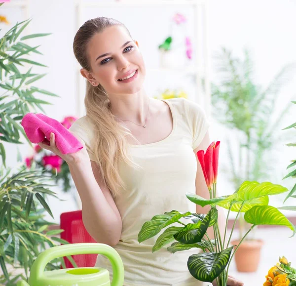 Jonge vrouw water geven planten in haar tuin — Stockfoto