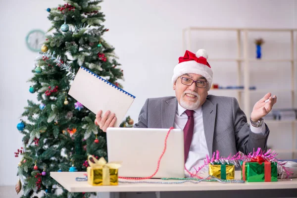 Funcionário idoso do sexo masculino comemorando o Natal no local de trabalho — Fotografia de Stock