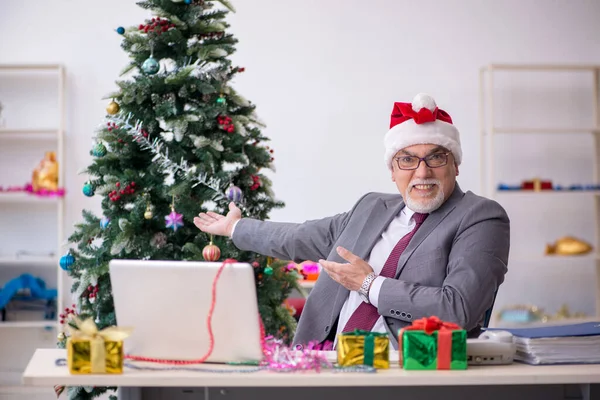 Funcionário idoso do sexo masculino comemorando o Natal no local de trabalho — Fotografia de Stock