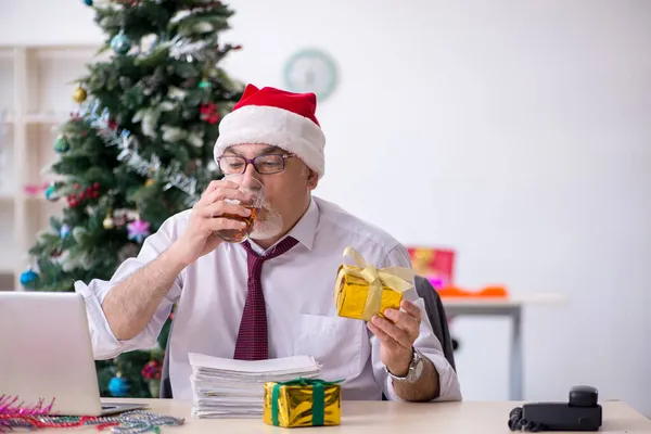 Funcionário idoso do sexo masculino comemorando o Natal no local de trabalho — Fotografia de Stock