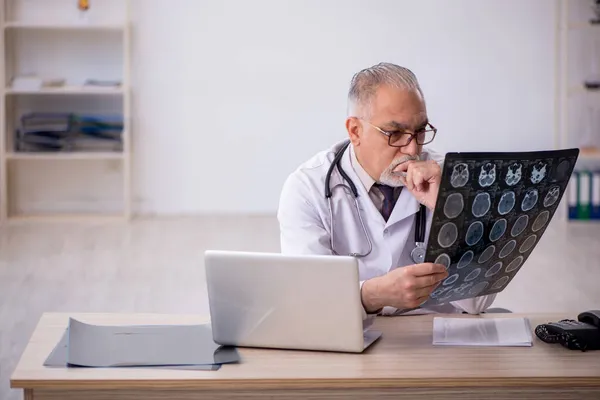 Старый врач-рентгенолог работает в больнице — стоковое фото