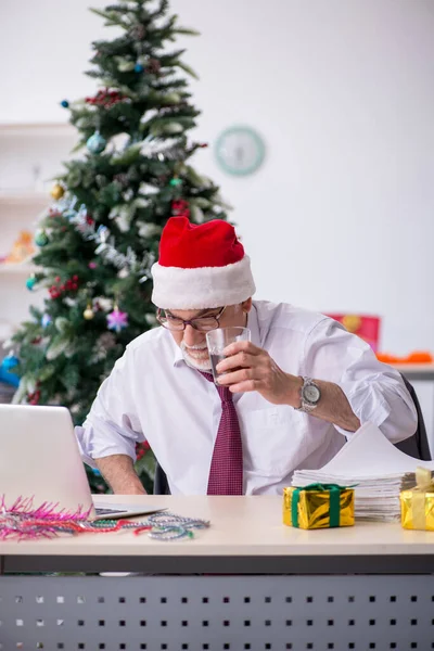 Alderen mandlige medarbejder fejrer jul på arbejdspladsen - Stock-foto