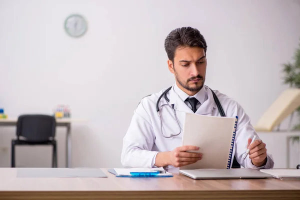 Ung manlig läkare som arbetar på kliniken — Stockfoto