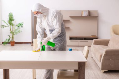 Genç erkek müteahhit evde haşere kontrolü yapıyor.