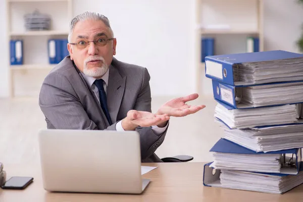 Old male employee unhappy with excessive work in the office — Stock Photo, Image