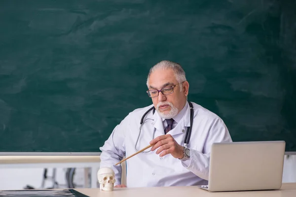 Velho professor de medicina na frente do quadro negro — Fotografia de Stock