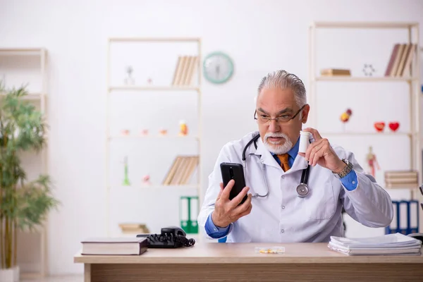 Velho médico do sexo masculino trabalhando na clínica — Fotografia de Stock