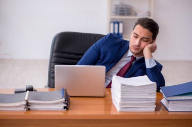 Genç işadamı ve ofiste çok fazla iş var.