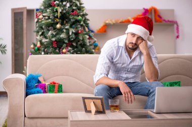 Genç adam Noel 'i evde yalnız kutluyor.
