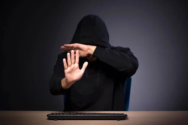 Jovem hacker masculino em fundo cinza — Fotografia de Stock