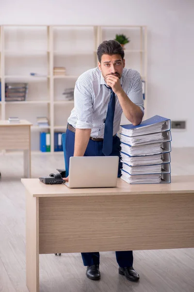 Jeune employé masculin et trop de travail au bureau — Photo