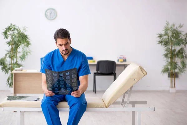 Ung manlig läkare radiolog sitter på kliniken — Stockfoto