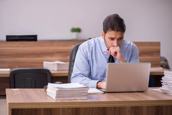 Junge männliche Mitarbeiter und zu viel Arbeit im Büro — Stockfoto