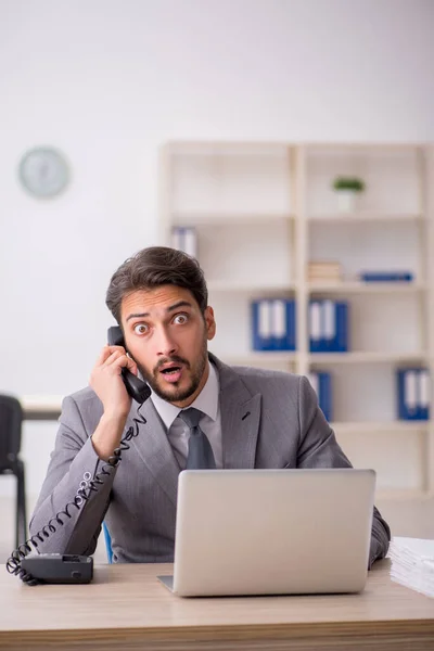 Jeune employé masculin et trop de travail au bureau — Photo