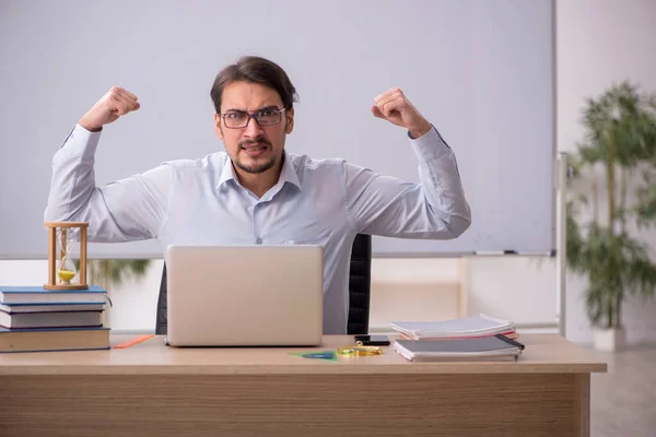 Joven profesor masculino en concepto de gestión del tiempo —  Fotos de Stock