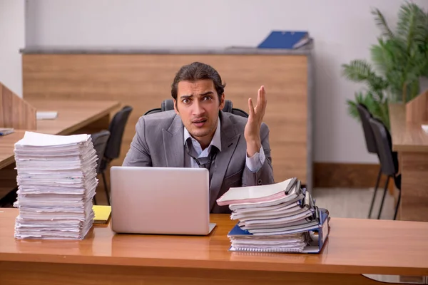 Junge männliche Mitarbeiter und zu viel Arbeit im Büro — Stockfoto