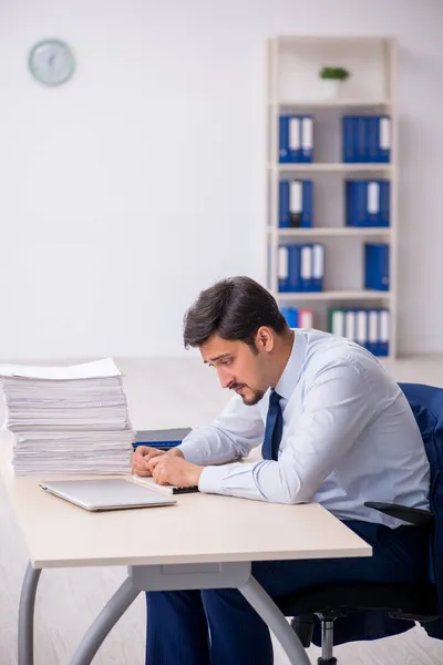 Jonge mannelijke werknemer en te veel werk op kantoor — Stockfoto