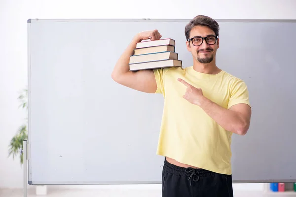 Jovem estudante do sexo masculino na frente do quadro branco — Fotografia de Stock