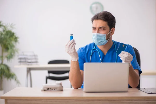 Jeune médecin tenant une carte de crédit pendant une pandémie — Photo