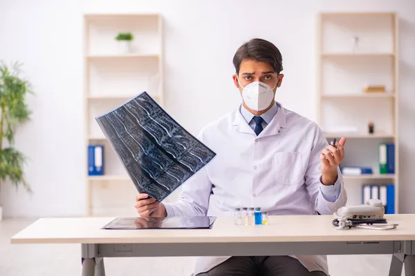 Jonge mannelijke arts radioloog werkzaam in de kliniek tijdens pande — Stockfoto