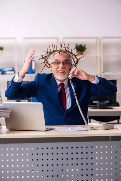 Starý muž zaměstnanec nosí pichlavý věnec na hlavě — Stock fotografie