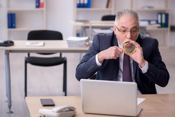 Viejo empleado sentado en el lugar de trabajo — Foto de Stock