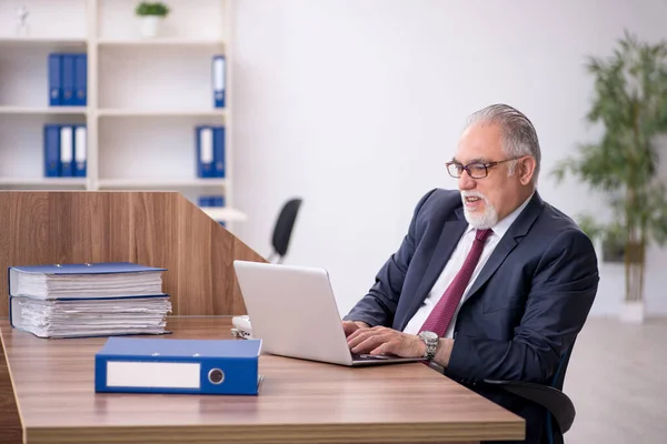 Velho empregado masculino e muito trabalho no escritório — Fotografia de Stock