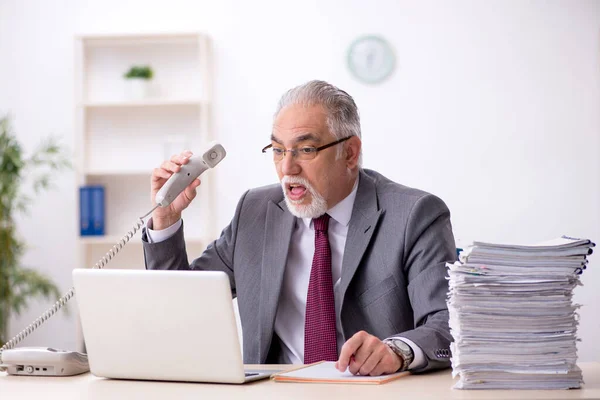 Velho empregado masculino e muito trabalho no escritório — Fotografia de Stock