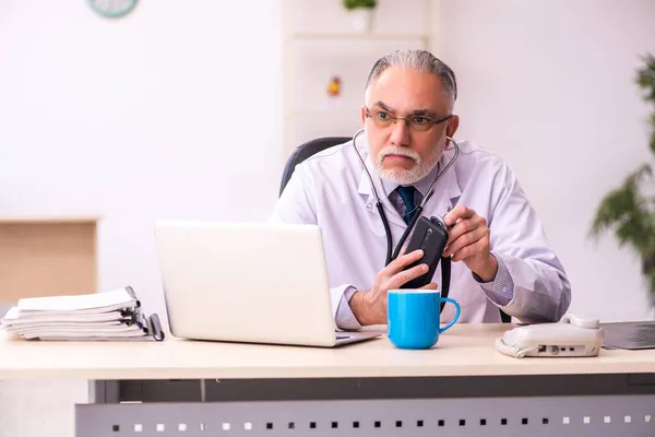 Ältere männliche Ärztin arbeitet in der Klinik — Stockfoto