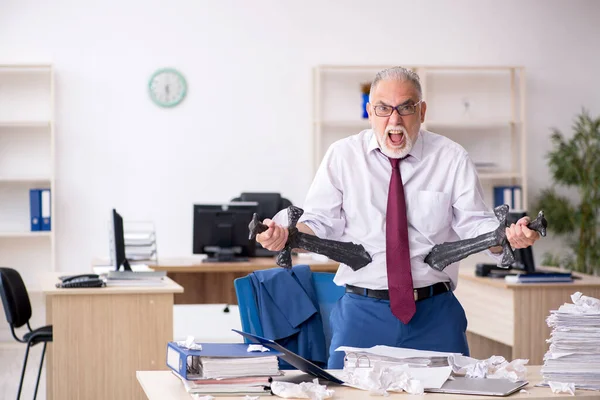 Vecchio dipendente maschio infelice con il lavoro eccessivo in ufficio — Foto Stock