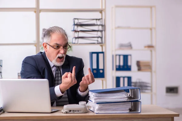 Vieil employé masculin mécontent du travail excessif au bureau — Photo