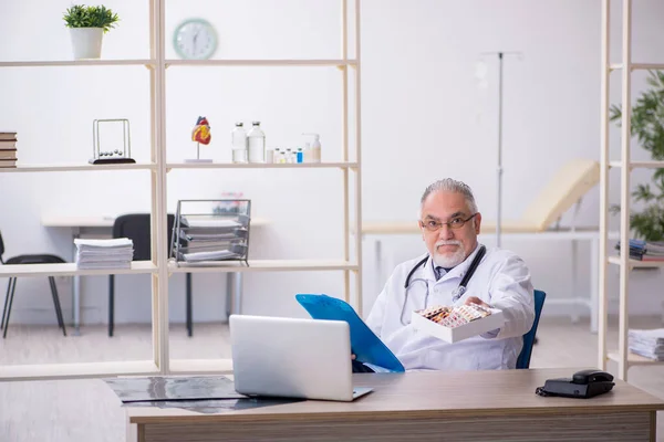 Старый врач-мужчина работает в клинике — стоковое фото