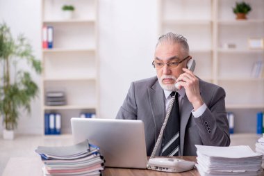 Ofiste çalışan yaşlı bir erkek.