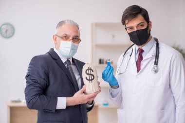 Yaşlı işadamı aşı danışmanıyla genç erkek doktoru ziyaret ediyor.